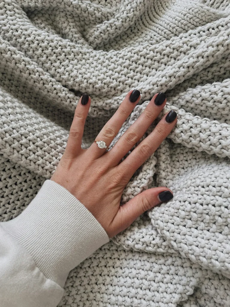 Dark short nails on a chunky knit blanket