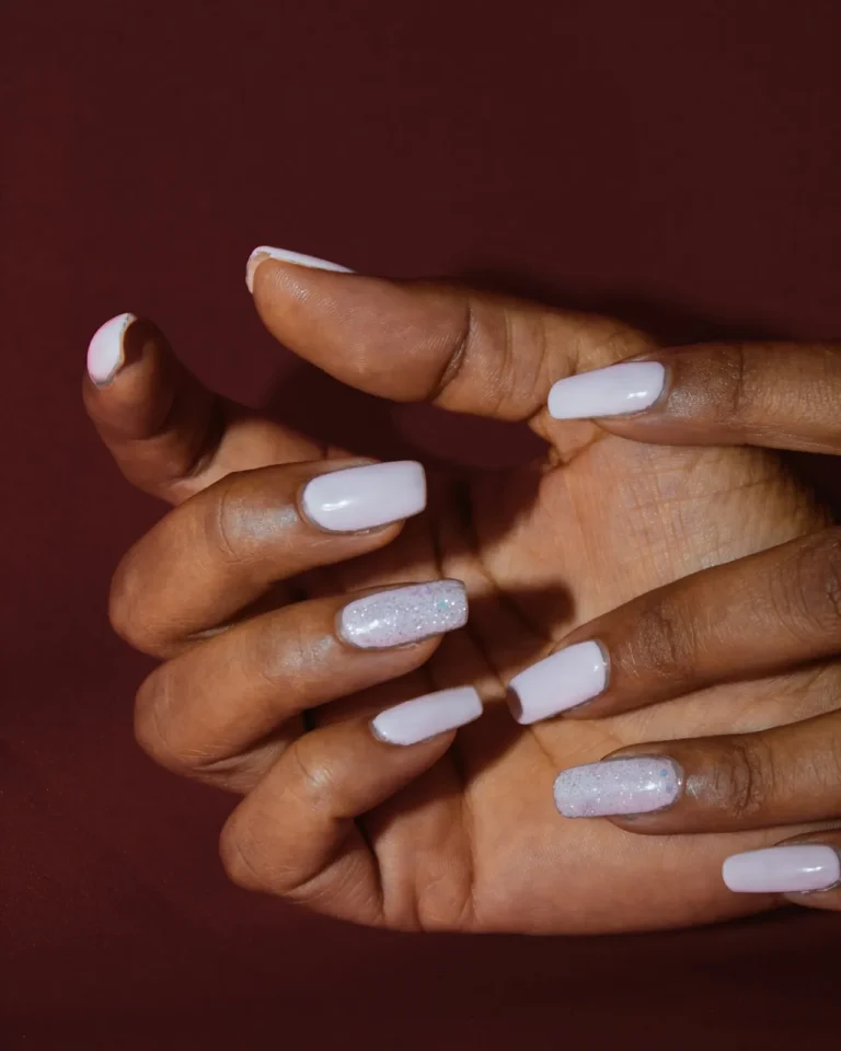 Glossy white nails on a burgundy backdrop