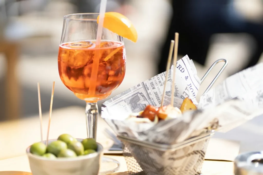 Spritz with olives and snacks on a terrace table