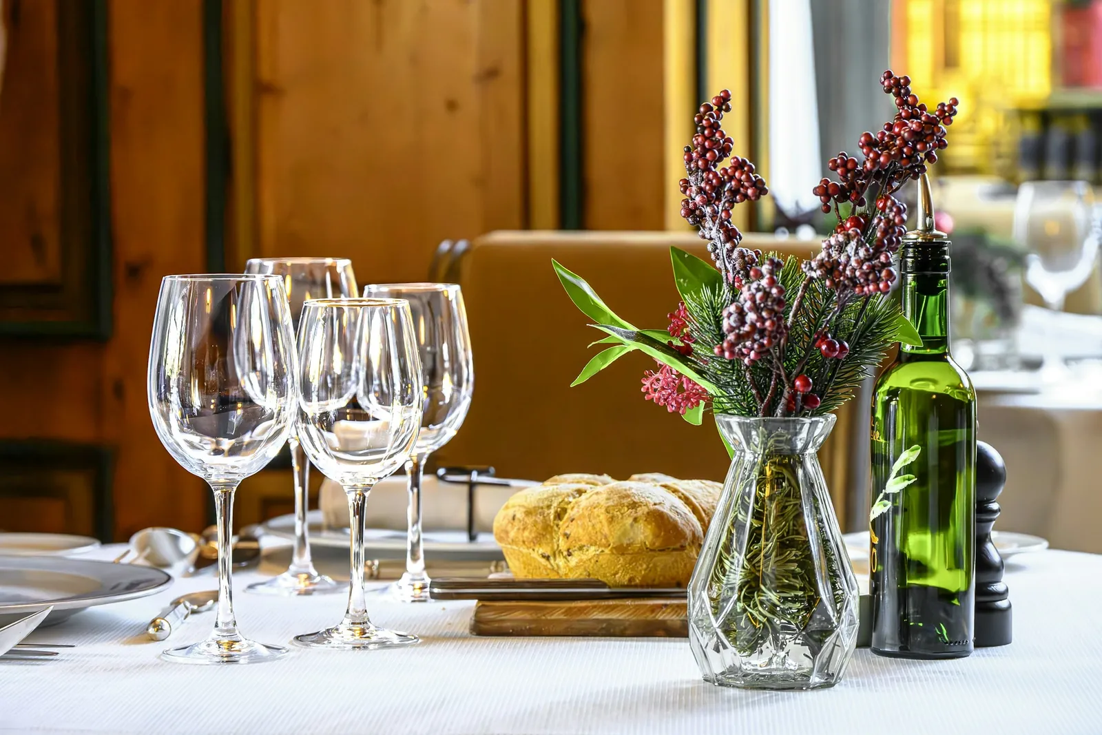 Wine glasses, flowers and bread on a white tablecloth
