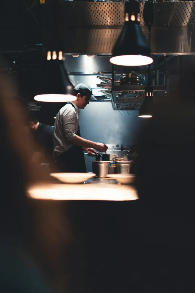 Cook at the stove under warm lamps