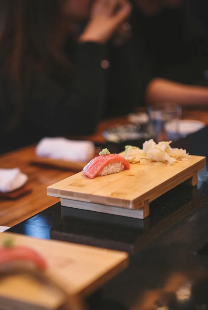 Nigiri served on a wooden board at the counter