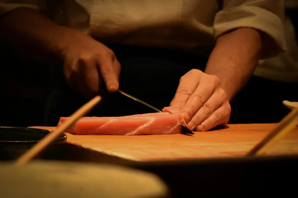 Slicing bluefin tuna on a wooden board