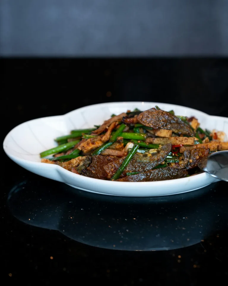 Beef stir-fried with green beans on a white plate