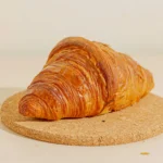 Butter croissant on a cork board