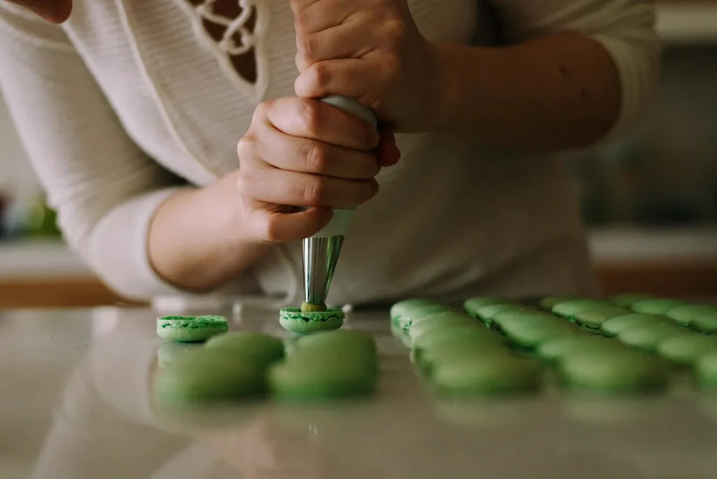 Piping pistachio macaron shells