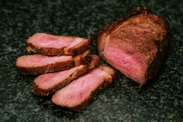 Sliced medium-rare steak on dark stone