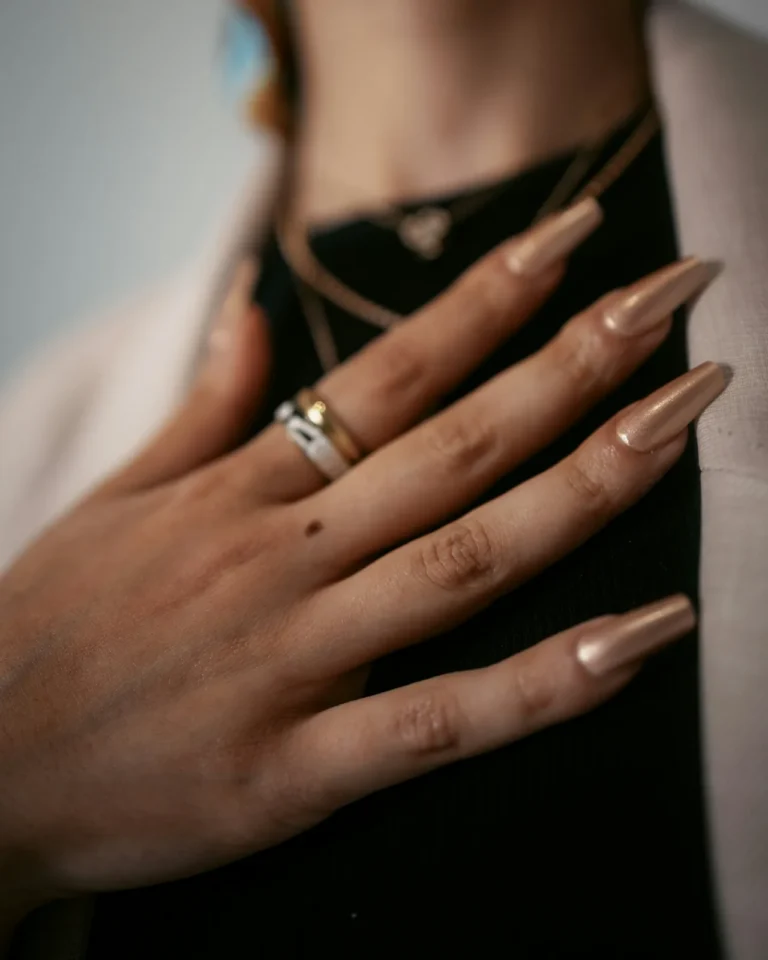 Long nude nails with silver and gold rings