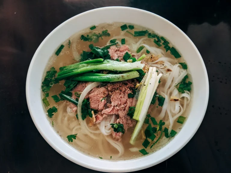Rare beef pho with scallions, seen from above