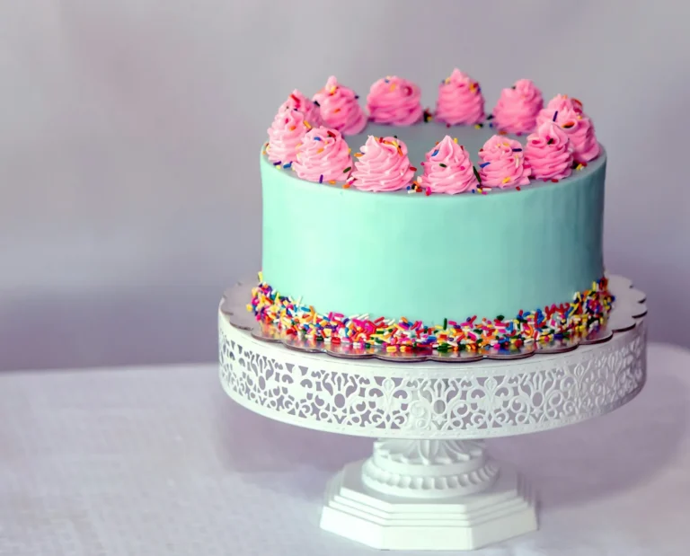 Mint cake with pink rosettes on a lace stand