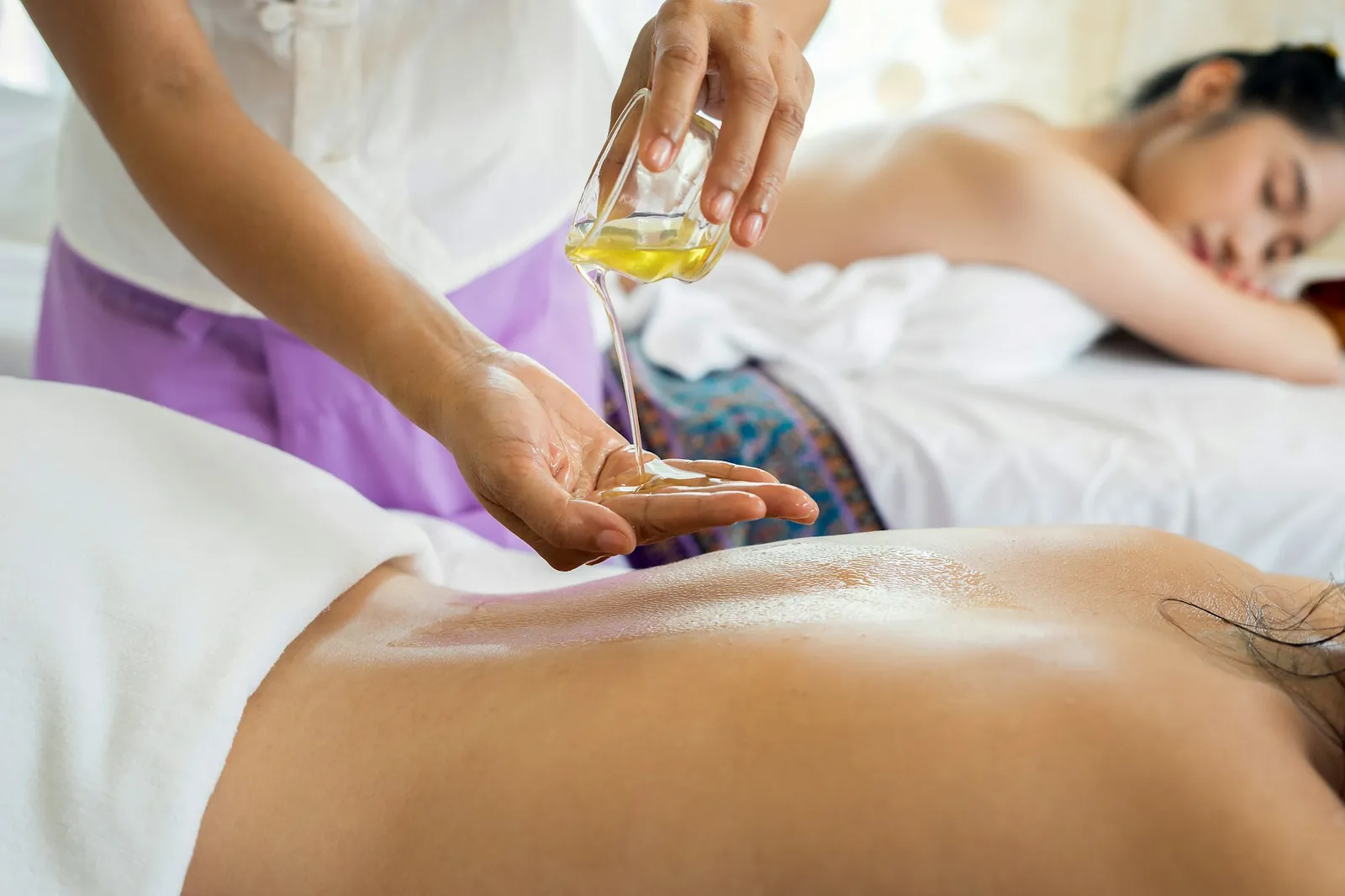 Therapist warming massage oil before a treatment