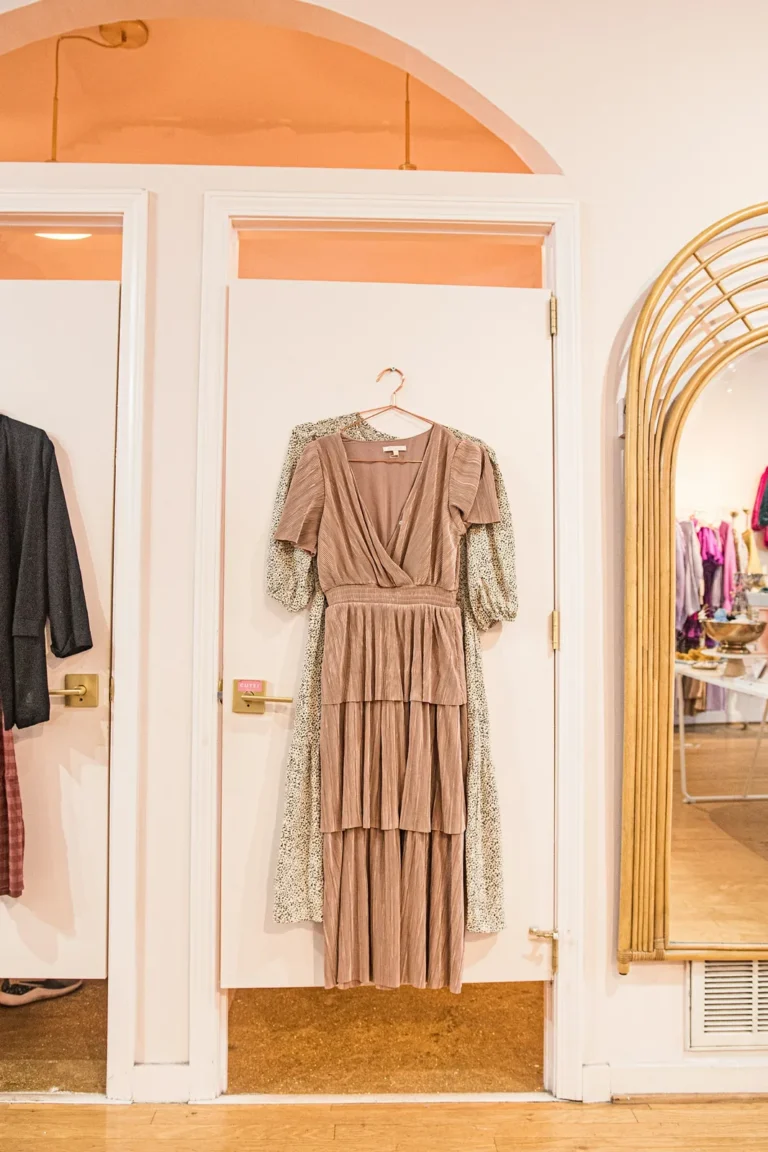 Blush dress on a hanger by an arched mirror