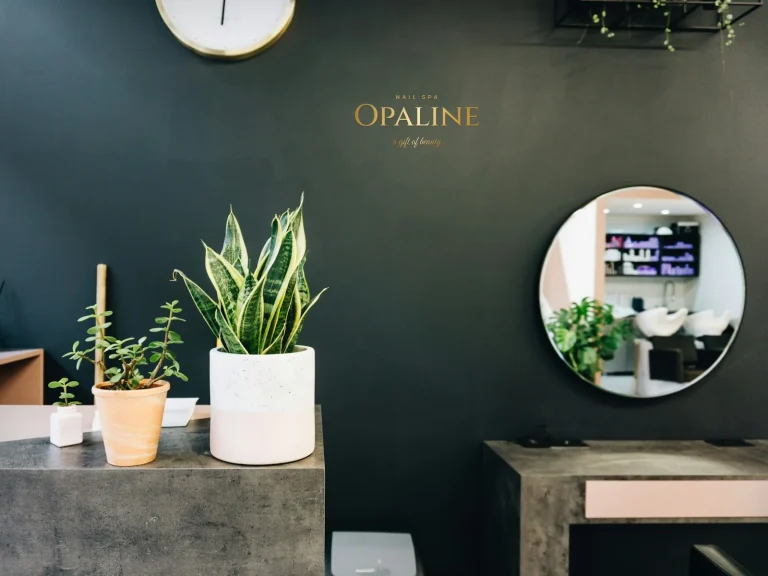 Decal cắt chữ màu vàng tên tiệm nail trên tường xanh rêu
