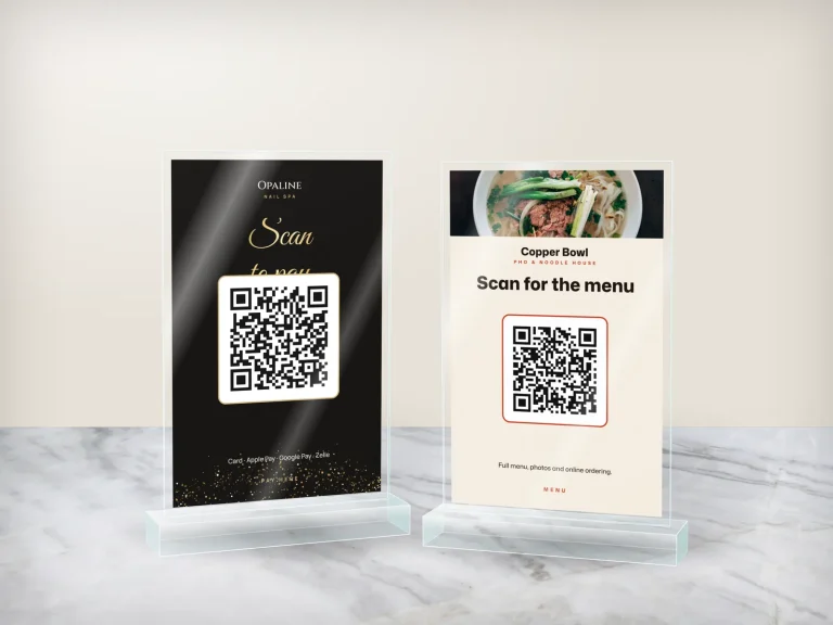 Hai standee mica để quầy: QR thanh toán của tiệm nail và QR menu của quán phở